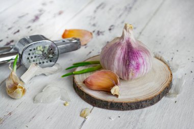 Sarımsak ve sarımsak beyaz ahşap arka plan basın. Close
