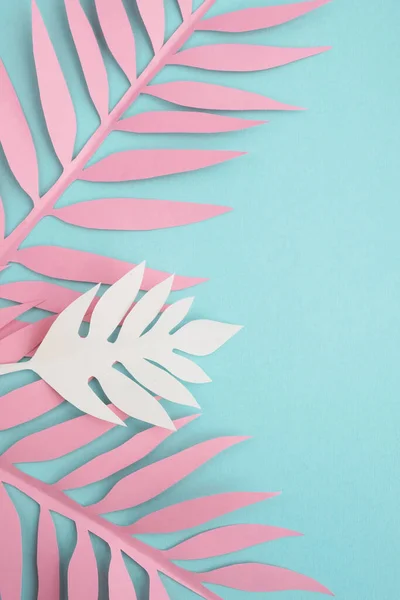 Paper tropical leaves on mint background. Bright summer composition. Top view, flat lay, copy space