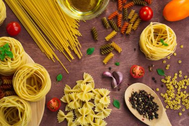Ahşap bir masada farklı bir makarna. Geleneksel İtalyan yemekleri. Üst görünüm