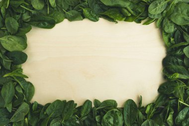 Ispanak yaprakları ve boş kesme tahtası. Yemek geçmişi, sağlıklı beslenme, yemek pişirme konsepti. Üst görünüm, boşluk kopyala, çerçeve