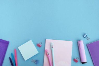 Açık mavi arka planda kırtasiye malzemeleri. Okul konseptine geri dönelim. Üst görünüm, düz görünüm, kopyalama alanı