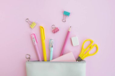 Pastel pembe arka planda ofis malzemeleri. Okul konseptine geri dönelim. Üst manzara, düz uzanma