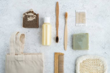 Banyo aksesuarları hazır. Tekstil alışveriş torbası, bambu diş fırçası, pamuk tomurcukları, tarak, doğal sabun, merhem ve bez. Sıfır atık, çevre dostu konsept. Üst manzara, düz uzanma