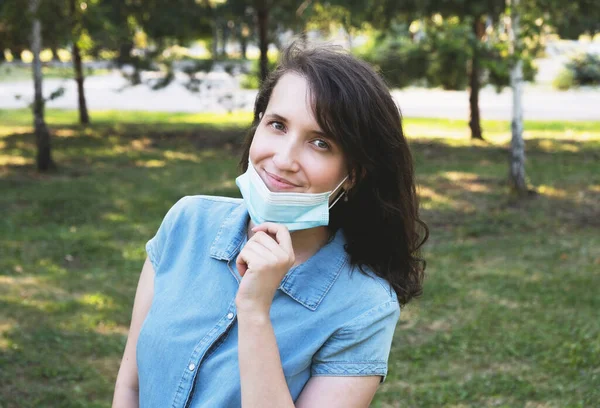 Tıbbi koruyucu maske takan mutlu genç bir kadının portresi. Coronavirus yaşam tarzı konsepti, yeni normal