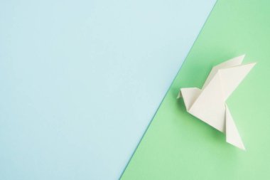 Pastel arka planda beyaz güvercin kuş origamisi. Uluslararası barış, umut ve özgürlük günü. Tasarım ya da tebrik kartı için hazırlan. Üst görünüm, alanı kopyala