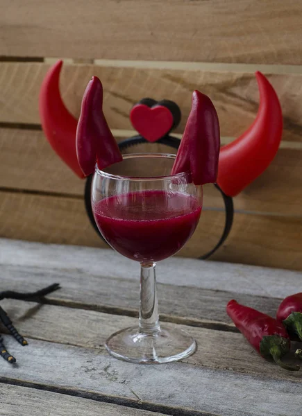 Red cocktail for Halloween celebration decorated with devil horns chili peppers. — Stock Photo, Image