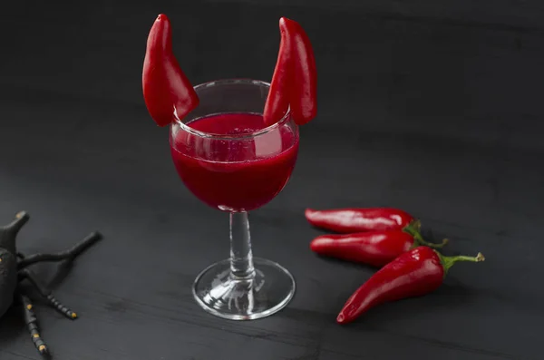 Red cocktail for Halloween celebration decorated with devil horns chili peppers — Stock Photo, Image