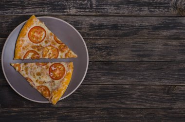 Peynirli pizza ve ahşap arka planda fotokopi alanı olan domatesler. Menüler ve reklam pizzacıları için.