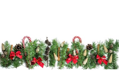 Noel ve Yeni Yıl kompozisyonu. Kozalaklı dallar, kozalaklar, tatlılar ve fiyonklar beyaz arka planda kopya alanı ile izole edilmiş. Düz yatıyordu. Yukarıdan görüntüle