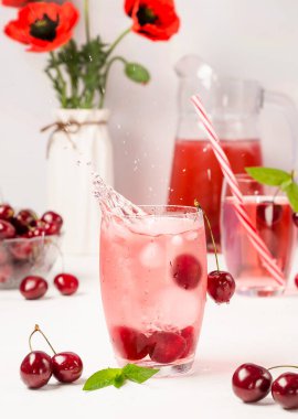 Beyaz ahşap bir zemine düşen bir buz damlası ile yaz tatlı kiraz içeceği. Dikey fotoğraf