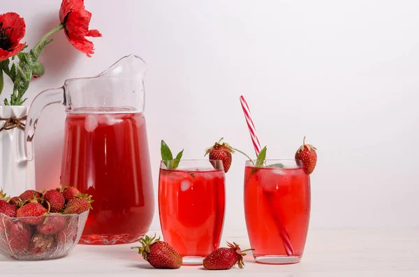 Summer cooling drink with strawberries and ice on a white background with copy space. Horizontal photo