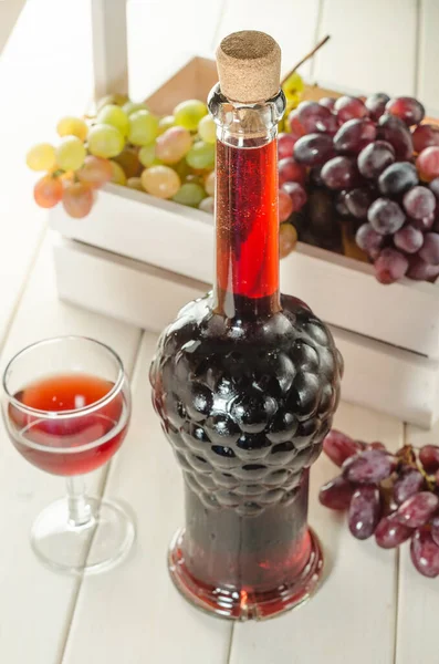Butelka Kieliszek Czerwonego Wina Winogronami Białym Drewnianym Tle Zbliżenie Zdjęcie — Zdjęcie stockowe