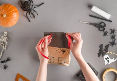 Cadılar Bayramı için bir hediyeyi adım adım paketliyorum. 19. Adım: Bandı çatıdaki deliklerden geçir.