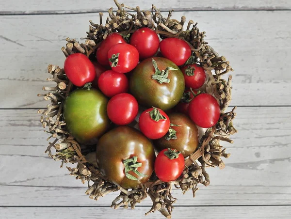 Green red and brown tomatoes in a basket, top view
