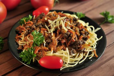 Domates ve maydanoz ile ahşap bir masada Bolonya soslu spagetti