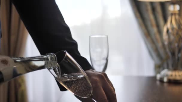 Ceketli Bir Adamın Eli Bir Şişeden Şarap Bardağına Köpüklü Şarap — Stok video