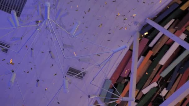 Конфеты Летят Сверху Вниз Потолку Цветных Досок Рядом Дизайнерской Люстрой — стоковое видео