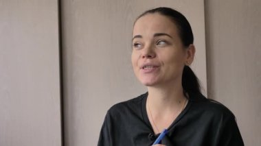 Güzel bir genç beyaz kız neşeli ilginç bir hikaye anlatıyor, aydınlık oda, ofis röportajlar verir. Uzun siyah saçlı, gri-yeşil gözleri, parmağında düğün yüzüğü, elinde mavi kalem var.