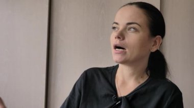 Güzel bir genç beyaz kız neşeli ilginç bir hikaye anlatıyor, aydınlık oda, ofis röportajlar verir. Uzun siyah saçlı, gri-yeşil gözleri, parmağında düğün yüzüğü, elinde mavi kalem var.