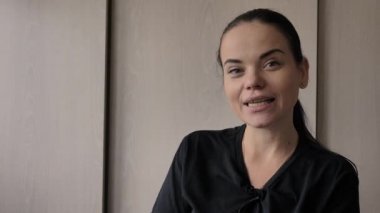 Güzel bir genç beyaz kız neşeli ilginç bir hikaye anlatıyor, aydınlık oda, ofis röportajlar verir. Uzun siyah saçlı, gri-yeşil gözleri, parmağında düğün yüzüğü, elinde mavi kalem var.