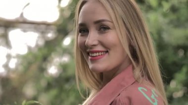 Kırmızı dudakları ve mavi gözleri ile güzel kız bir kenara birine tatlı gülümsüyor