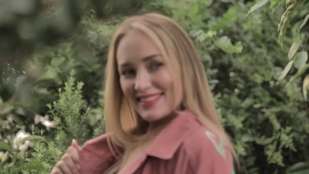 Beautiful girl with red lips and blue eyes smiles sweetly to someone aside — Stock Video