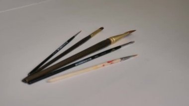 farklı boyutlarda fırçalar, boyalar ile boyama için, beyaz bir masa üzerinde yalan.