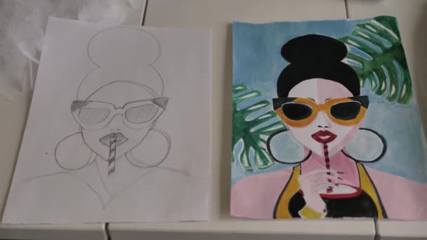 Stole Dwa Arkusze Papieru Szkicem Rysunek Dziewczyny Okularami Picia Drinka — Wideo stockowe