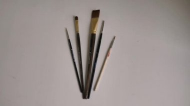 farklı boyutlarda fırçalar, boyalar ile boyama için, beyaz bir masa üzerinde yalan.