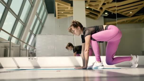바닥에 스트레칭 운동을하고 스포츠웨어에 배경에서 거울에 그녀의 스테인드 글라스 발레리나 — 비디오
