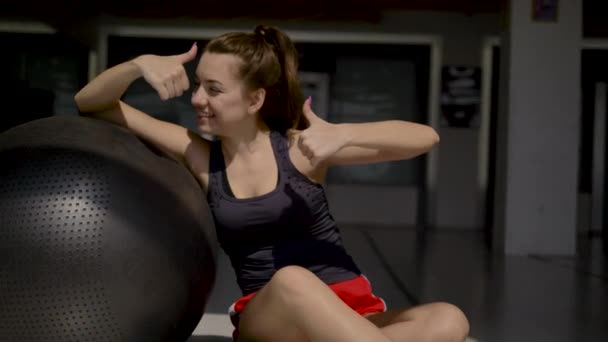 Morena Caucásica Ropa Deportiva Sentada Suelo Apoyada Una Pelota Gimnasia — Vídeo de stock