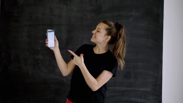 Καυκάσιος Μελαχρινή Αθλητικά Είδη Κρατά Ένα Smartphone Στο Χέρι Της — Αρχείο Βίντεο