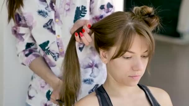 ヘアスタイリストは 若い美しい白人ブルネットのヘアスタイルを作ります ミディアムプラン 自然照明 — ストック動画
