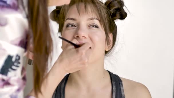 Maquillaje Artista Hace Maquillaje Una Hermosa Joven Morena Caucásica Primer — Vídeos de Stock
