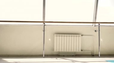 Çizgili pantolon neşeli genç sarışın şiddetle ve komik bir vitray pencereye karşı beyaz bir odada dans.