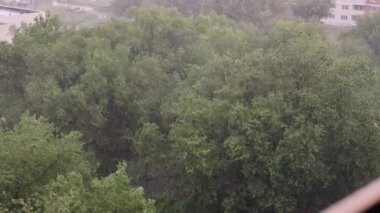 Kar yağışı ve yaz aylarında şiddetli yağmur. Arka planda yeşil ağaçlar, çimenler, patika lar var. Yukarıdan görüntüleyin. Anormal doğal fenomen. Yavaş çekim.