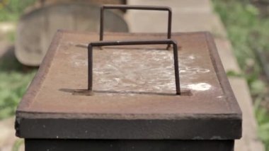 Erkeklerin elleri, yemeye hazır bir balığın bulunduğu duman evinin metal kapağını açar. Büyük bir plan. Yaz.