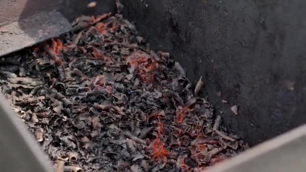 Brûlure de charbon dans une boîte métallique. Les étincelles volent, plan rapproché .