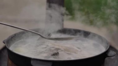 Pişirme balık çorbası açık havada, su köpük ve bol buhar yüzeyinde, yakın çekim, yaz
