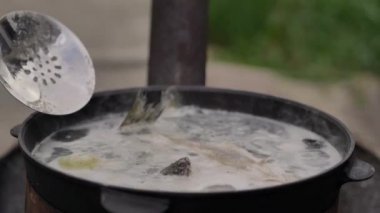 Pişirme balık çorbası açık havada, su köpük ve bol buhar yüzeyinde, yakın çekim, yaz