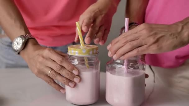 Female Hands Pour Pink Milkshake Transparent Glass Goblet Next Girl — Stock Video