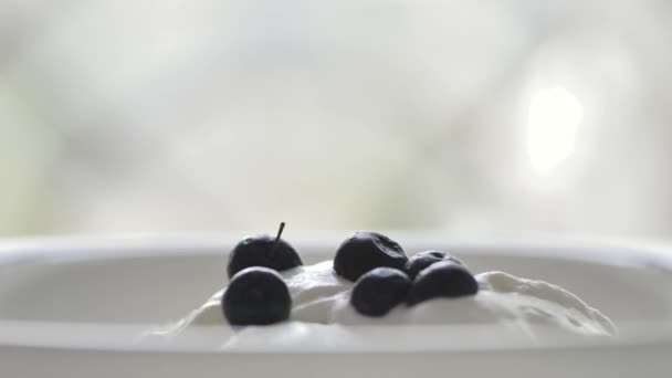 Les Baies Noires Tombent Sur Une Crème Glacée Blanche Haut — Video