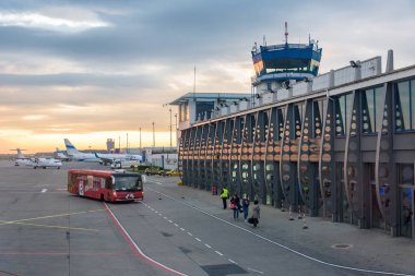 Katowice Airport, Poland - April 26, 2018: People board their plane on the Katowice-Pyrzowice International Airport at sunrise clipart