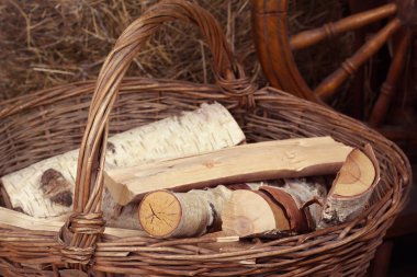 Bölünmüş Birch bir hasır sepet içinde haystacks ve iğ arka planda bir kolu ile yalan günlükleri