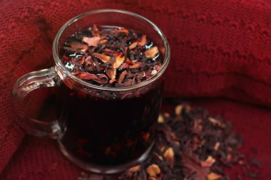 Kuru nar yaprakları bir Bordo örme arka planda demlenmiş Nar Çayı ile bir kupa yakın yalan
