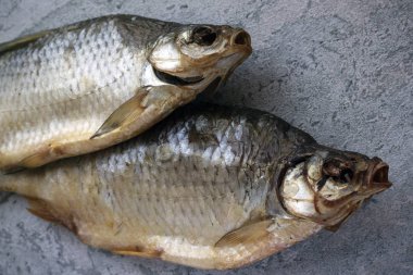 kurutulmuş altın balık, nehir balığı, gri bir masa üzerinde yatıyor