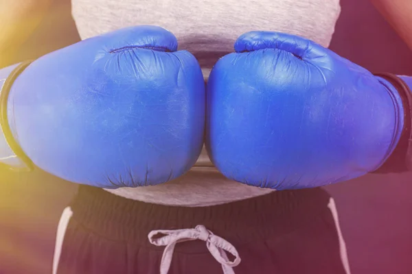 female boxing girl in blue boxing gloves in the foreground