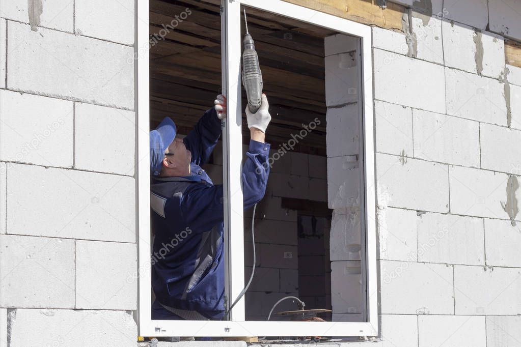 Asian workers install windows to house construction and renovation