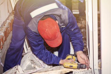 İşçiler özel formda plastik pencereleri ev onarımı için kurar