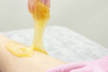 güzellik salonunda depilasyon için cilde shugaring macun uygulayarak şeker depilasyon kozmetik prosedür